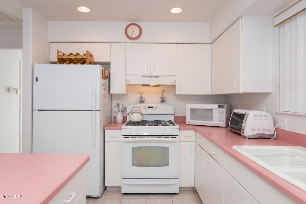 3570 Big Pine Road Melbourne, FL 32934 - Photo 11 of 27 a kitchen with a stove cabinets and refrigerator