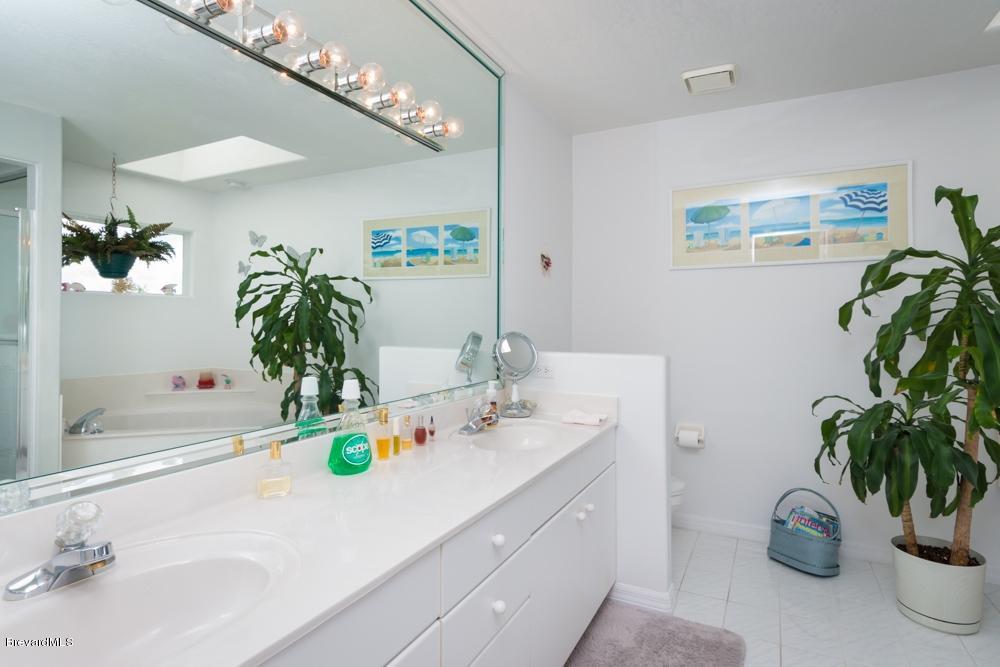 3570 Big Pine Road Melbourne, FL 32934 - Photo 16 of 27 a bathroom with a sink a mirror and a potted plant