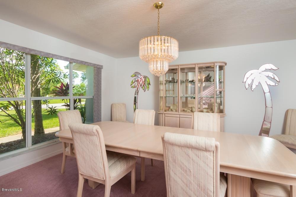 3570 Big Pine Road Melbourne, FL 32934 - Photo 6 of 27 a view of a dining room with furniture wooden floor and chandelier
