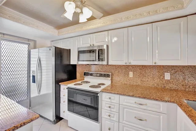a kitchen with cabinets stainless steel appliances and a counter space