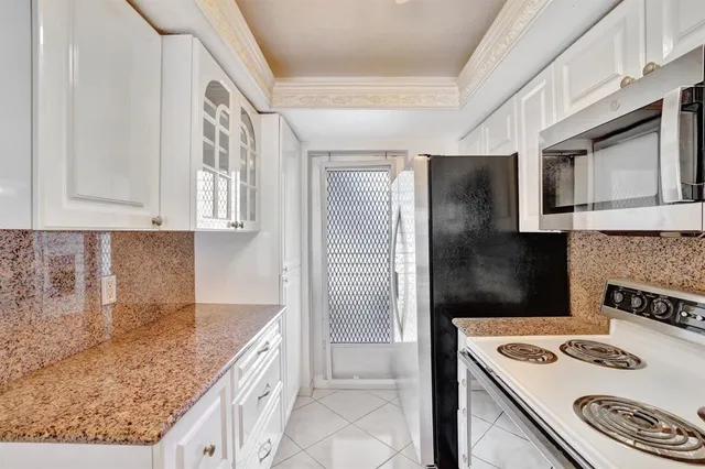 a kitchen with cabinets and wooden floor