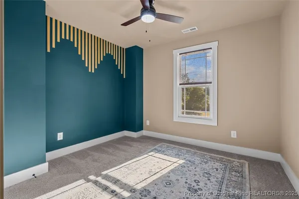 a view of an empty room with stairs and a window