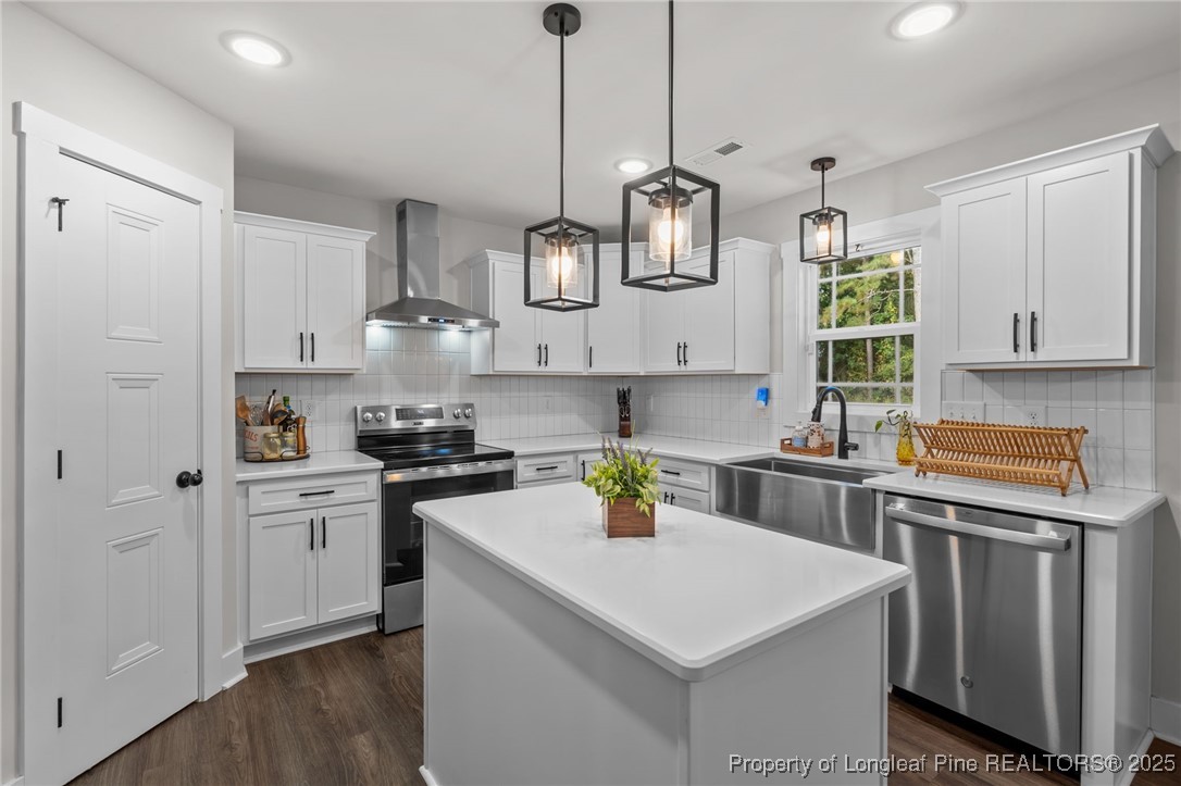 247 North Horace Walters Road Raeford, NC 28376 - Photo 3 of 35 a kitchen with stainless steel appliances granite countertop a sink a stove a refrigerator and white cabinets with wooden floor
