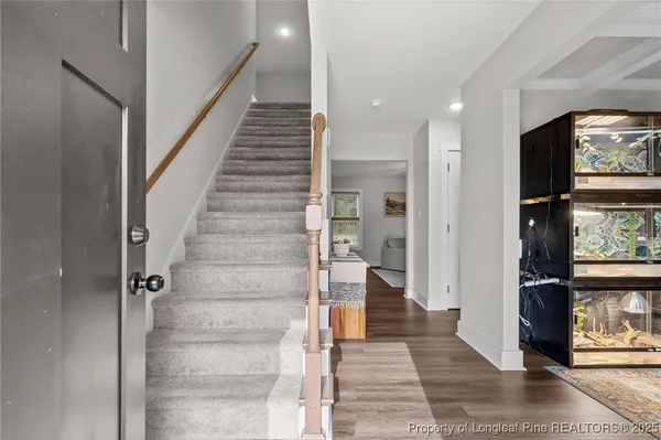 a view of a hallway with wooden floor and staircase