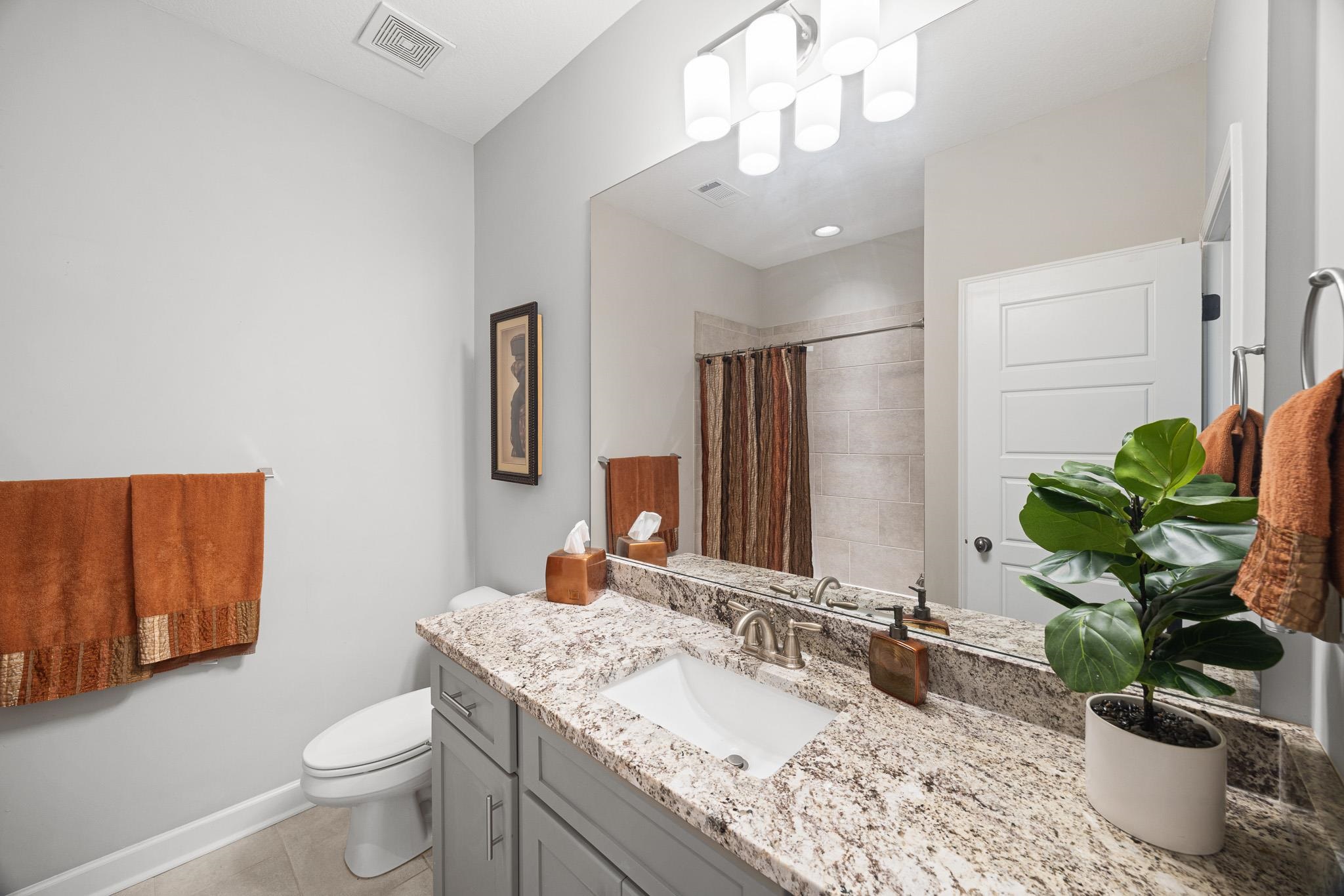 4711 Carousel Lane Collierville, TN 38017 - Photo 26 of 33 a bathroom with a granite countertop toilet a sink and a mirror