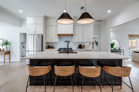 a kitchen with stainless steel appliances a dining table and chairs