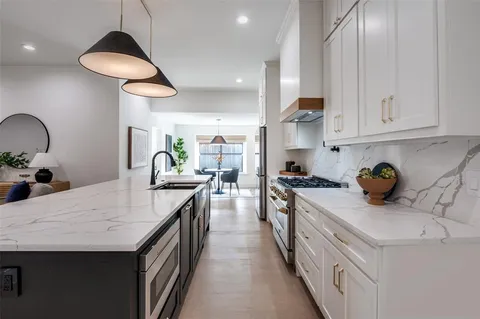 a kitchen with granite countertop a sink a counter space and cabinets