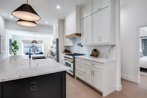 a kitchen with stainless steel appliances granite countertop a sink a stove and a refrigerator