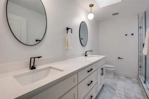 a bathroom with a sink a toilet and a mirror