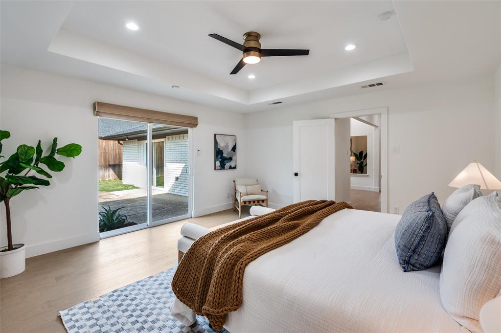 6322 Pineview Road Dallas, TX 75248 - Photo 30 of 40 a bedroom with a large bed and a chandelier