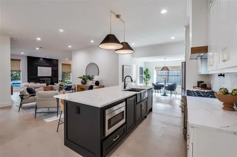 a kitchen with a stove a refrigerator and a dining table with wooden floor