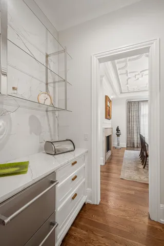 a kitchen with stainless steel appliances granite countertop white cabinets a stove a sink and a large window with wooden floor