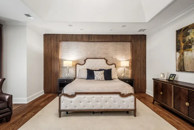 a bedroom with a bed and a flat tv screen on the dresser