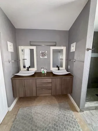 a large bathroom with a double vanity sink mirror and bathtub