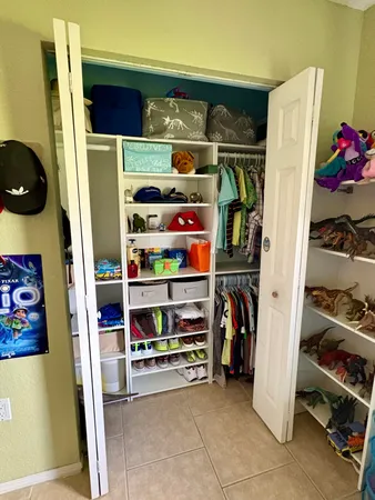 a view of walk in closet with clothes and shoes