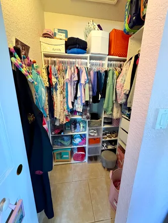 a view of walk in closet with clothes and shoes