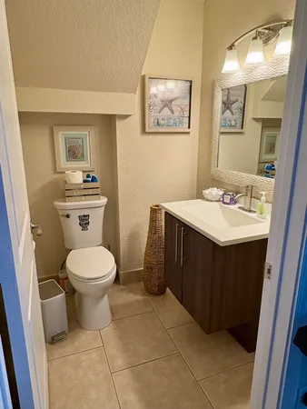 a bathroom with a toilet sink vanity and mirror