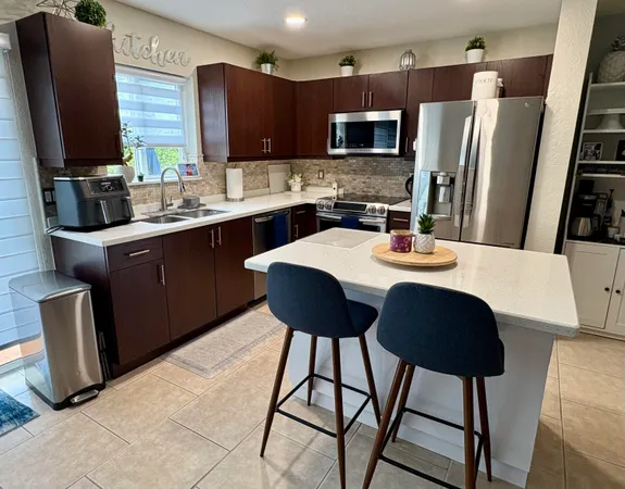 a kitchen with stainless steel appliances granite countertop a sink refrigerator and microwave