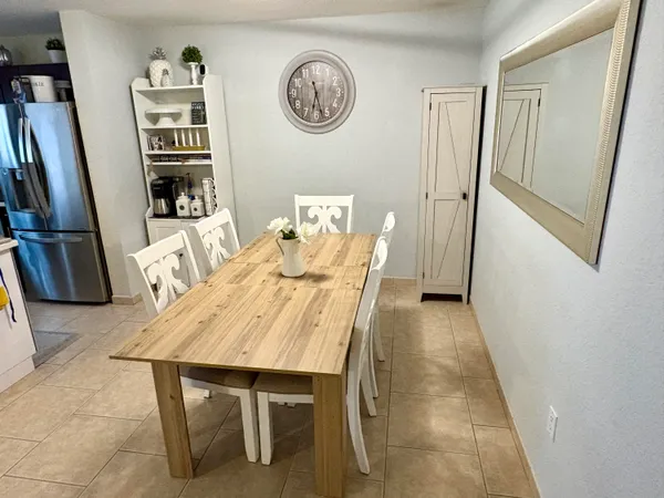 a view of a dining room with furniture and a refrigerator