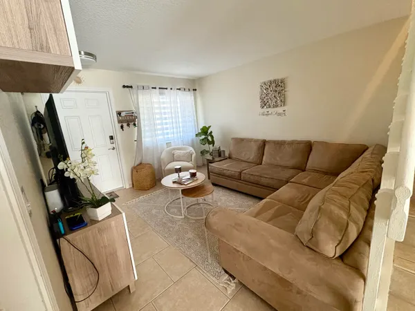 a living room with furniture a window and a flat screen tv