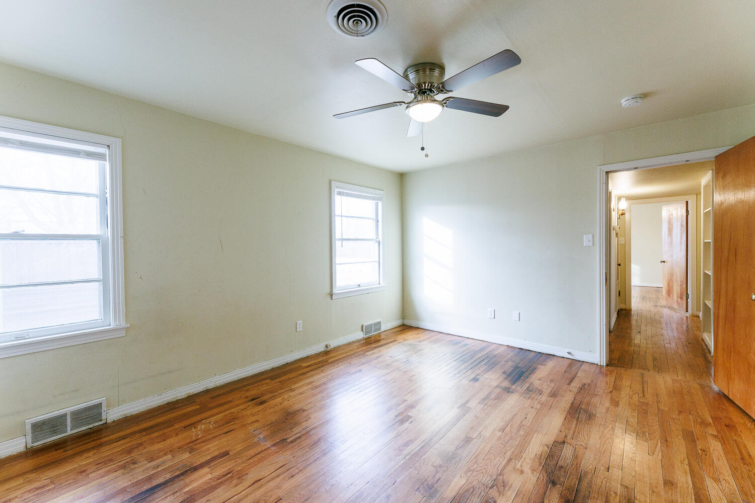 3501 26th Street Lubbock, TX 79410 - Photo 19 of 36 an empty room with wooden floor fan and windows