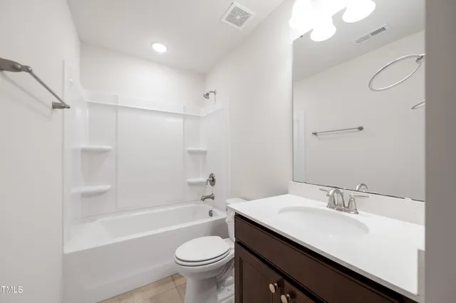 a bathroom with a tub sink shower and mirror