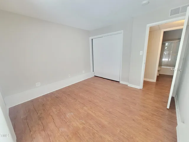 a view of an empty room with wooden floor