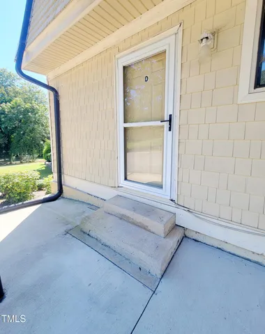 an aerial view of a house with swimming pool and large trees