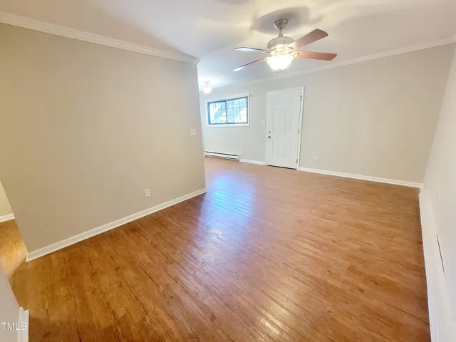 an empty room with a ceiling fan and carpet