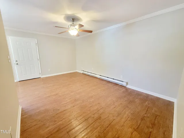a view of an empty room with wooden floor