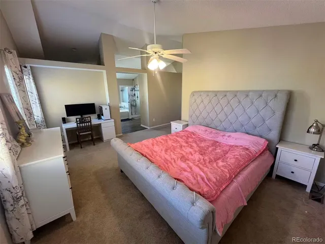 a spacious bedroom with a bed and a chandelier