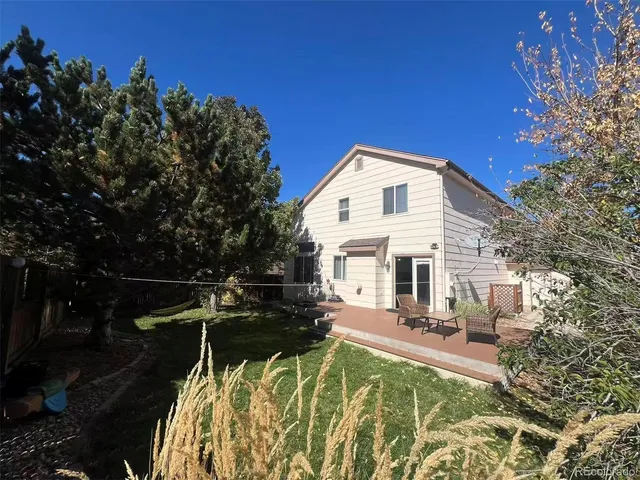 a view of house with patio outdoor seating and covered with trees