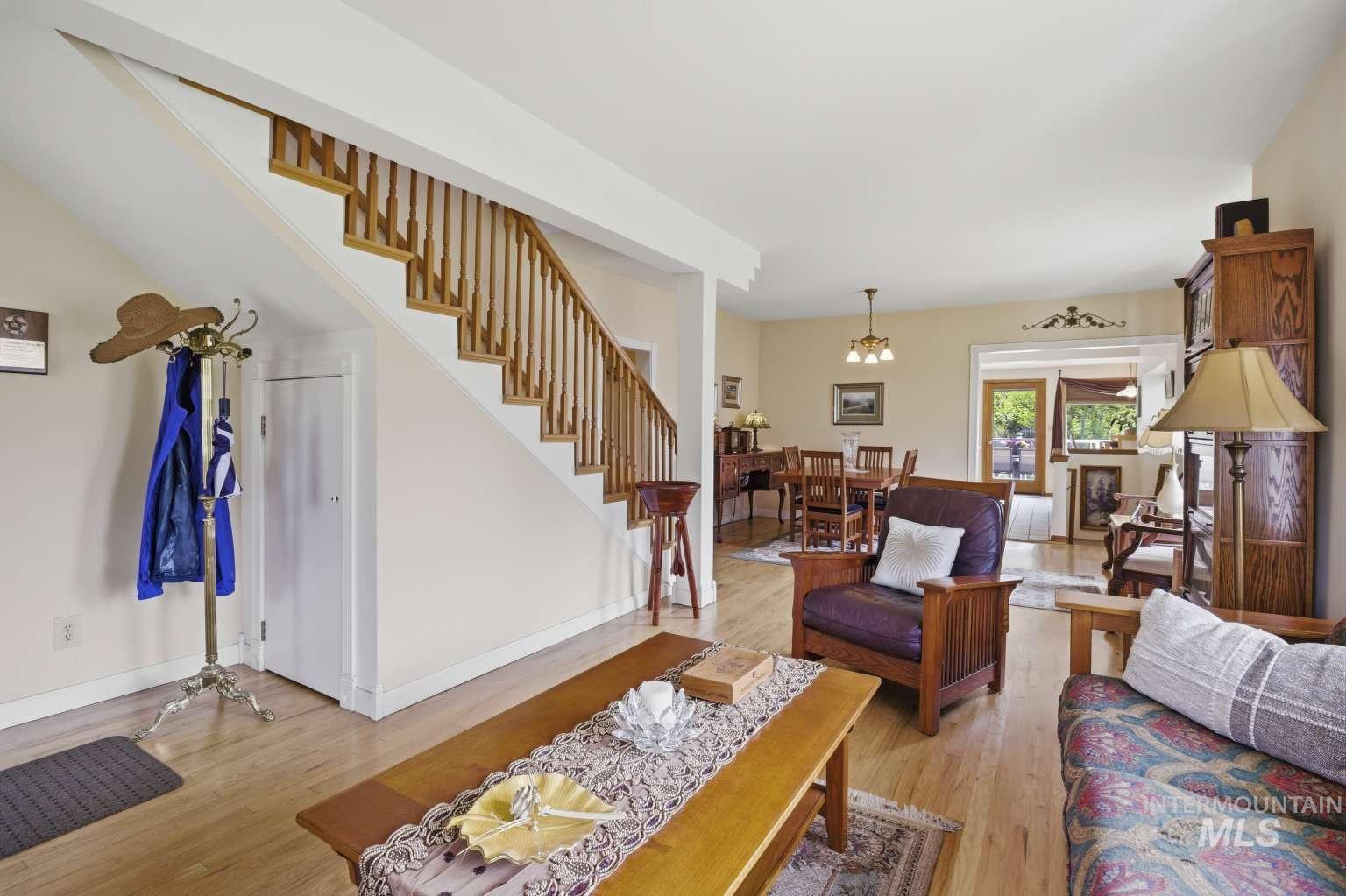 901 Main Street Kendrick, ID 83537 - Photo 8 of 50 Brightly lit living area featuring light wood-finish flooring, multiple windows with decorative treatments, and neutral wall tones