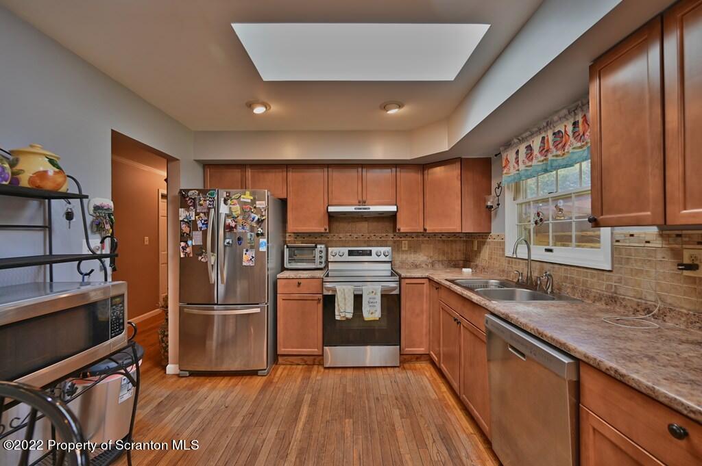 217 Hemlock Road Lake Ariel, PA 18436 - Photo 17 of 54 a kitchen with stainless steel appliances granite countertop a refrigerator a sink dishwasher a stove with wooden cabinets and floor