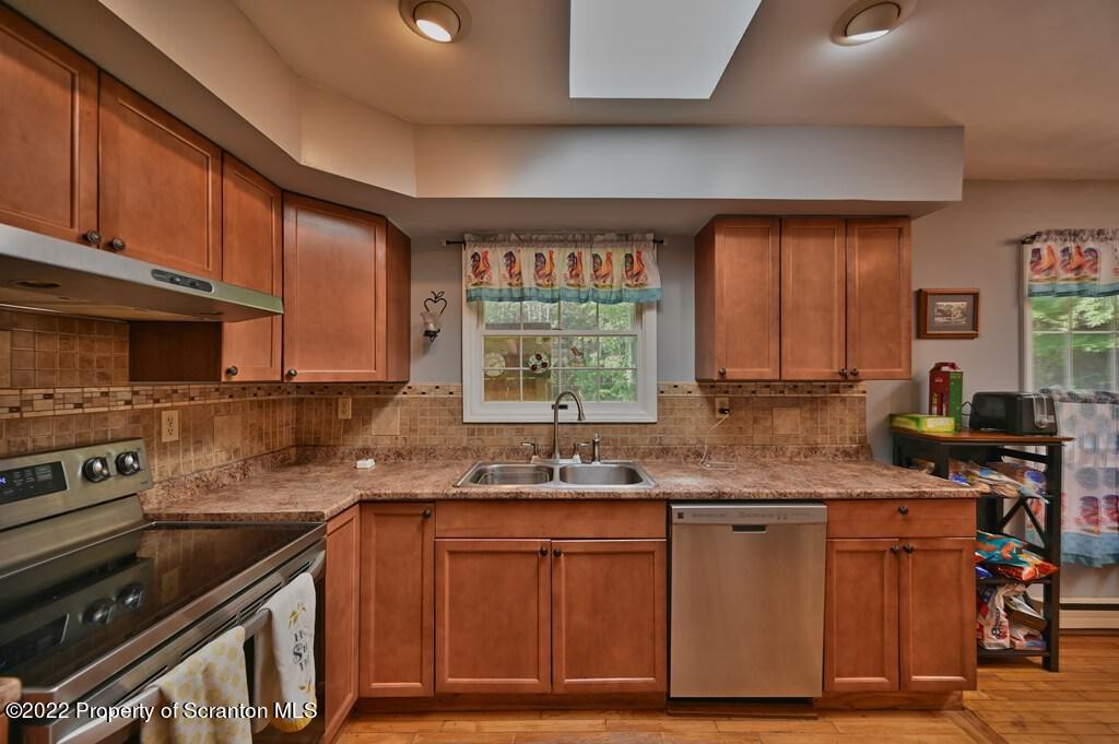 217 Hemlock Road Lake Ariel, PA 18436 - Photo 23 of 54 a kitchen with granite countertop wooden cabinets a stove a sink and a window