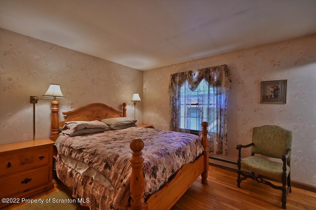 217 Hemlock Road Lake Ariel, PA 18436 - Photo 28 of 54 a bedroom with a bed a dresser and painting on the wall