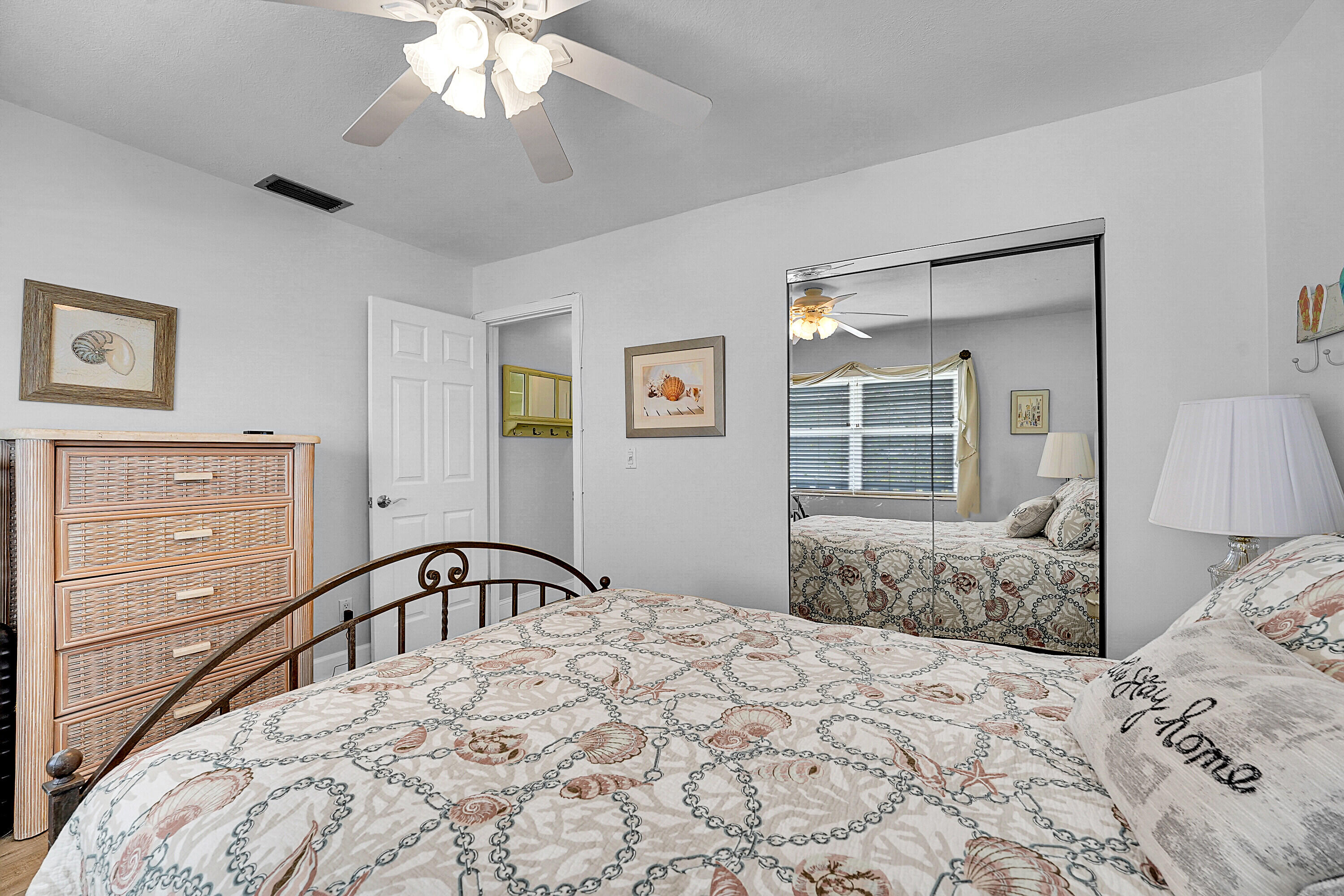 2929 Southeast Ocean Boulevard, Unit 13610 Stuart, FL 34996 - Photo 15 of 27 a bedroom with a large bed and a dresser