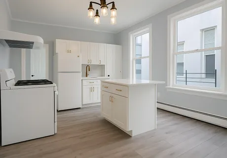 a kitchen with white cabinets and white appliances