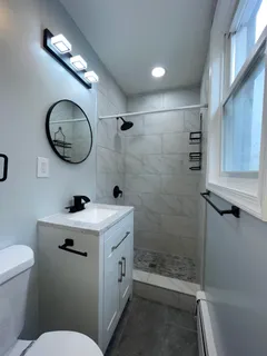 a bathroom with a sink a toilet and shower