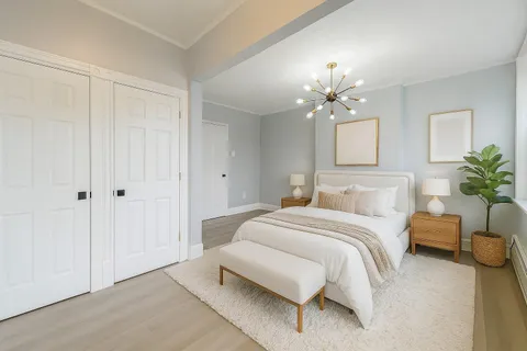 a spacious bedroom with a bed and a chandelier