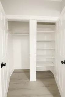 a view of walk in closet with empty racks
