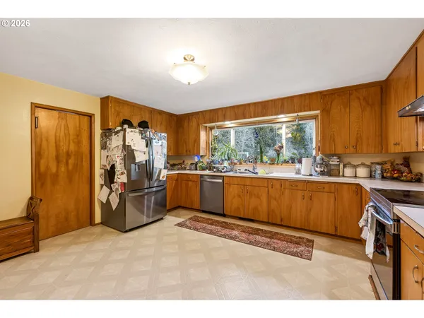 a living room with stainless steel appliances kitchen island granite countertop furniture and a large window
