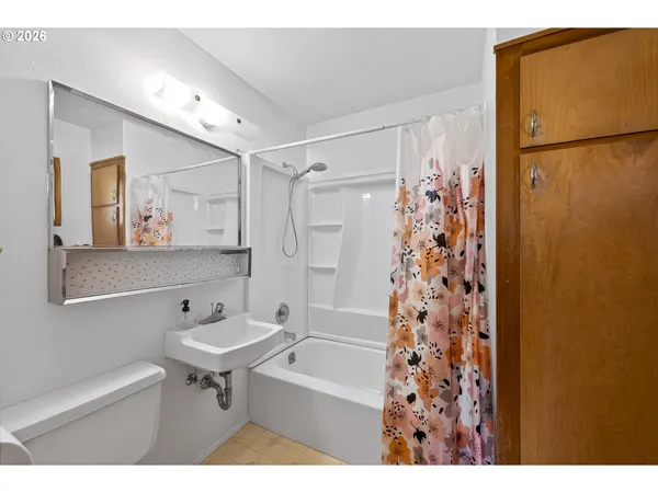 a bathroom with a sink a mirror a shower and a toilet