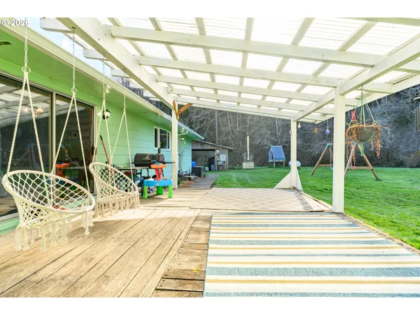 a view of a patio with table and chairs with wooden floor and fence