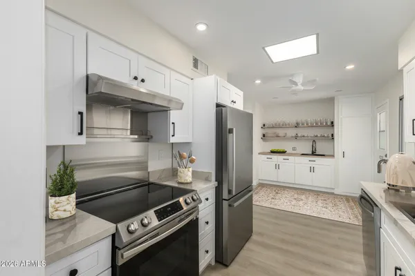 a kitchen with stainless steel appliances kitchen island granite countertop a refrigerator and a stove top oven