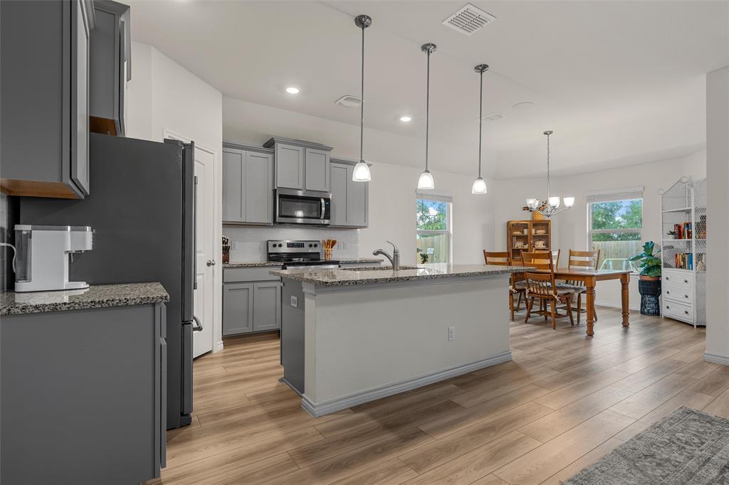 10712 Peperak Court Waco, TX 76708 - Photo 7 of 25 a kitchen with stainless steel appliances granite countertop a refrigerator a oven a sink a stove and a wooden floors