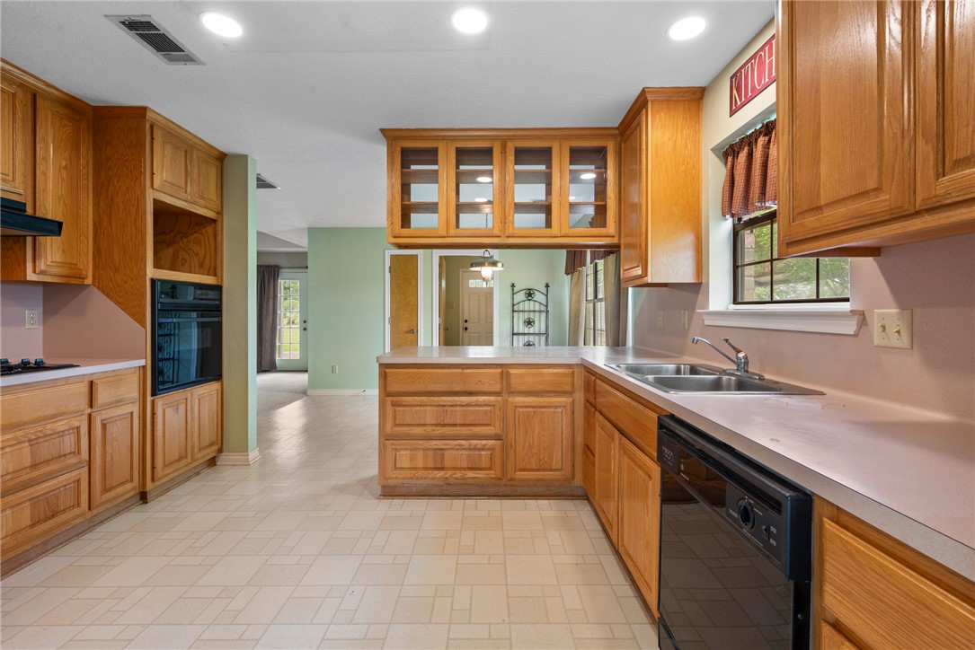 9393 Locke Road Bryan, TX 77808 - Photo 12 of 39 a large kitchen with stainless steel appliances granite countertop a sink and cabinets