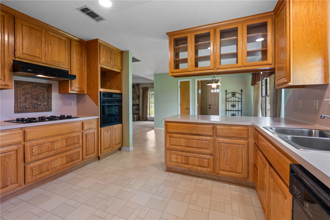9393 Locke Road Bryan, TX 77808 - Photo 13 of 39 a kitchen with granite countertop a sink and cabinets