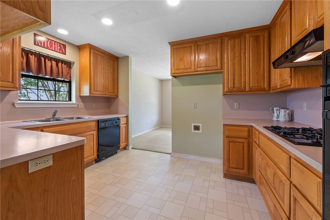 9393 Locke Road Bryan, TX 77808 - Photo 14 of 39 a kitchen with granite countertop stainless steel appliances a stove sink and cabinets