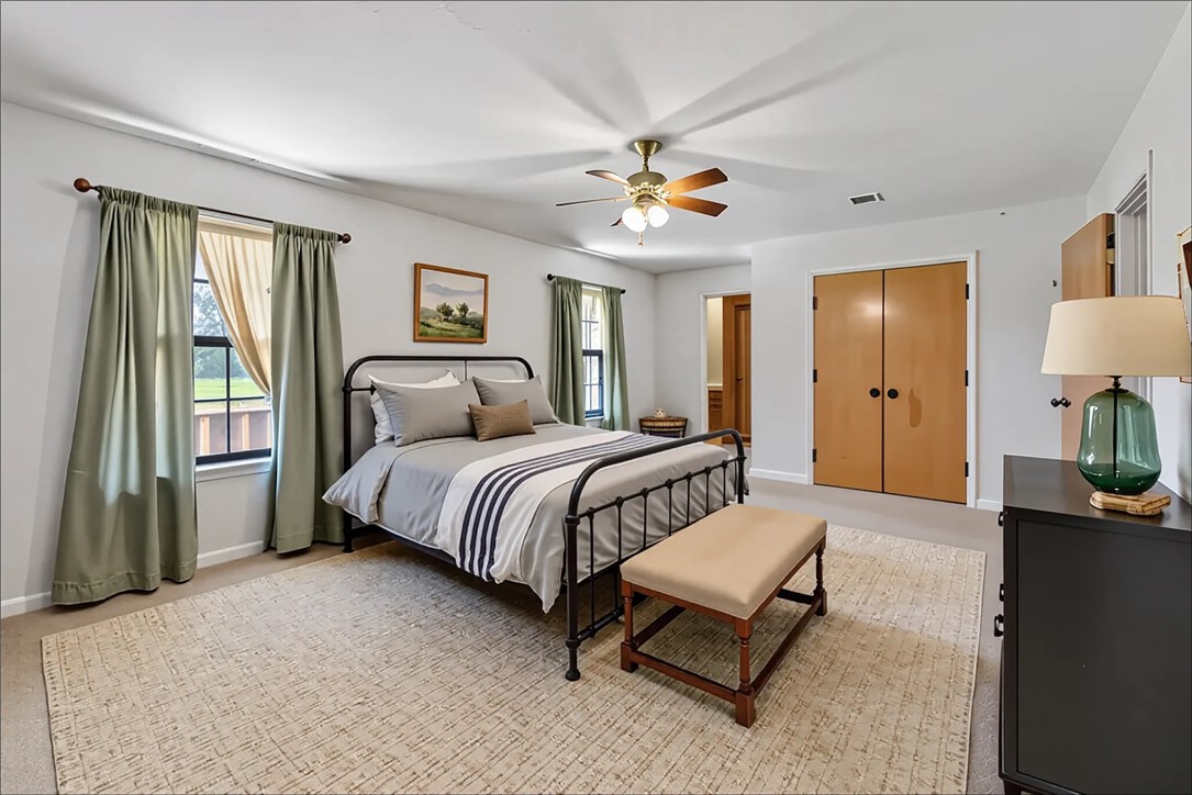 9393 Locke Road Bryan, TX 77808 - Photo 22 of 39 a spacious bedroom with a bed and a chandelier